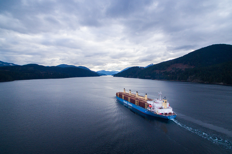 A ship loaded with raw logs leaves the Alberni Inlet on Vancouver Island.